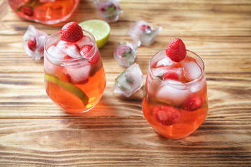 Glasses with strawberry mojito on wooden table