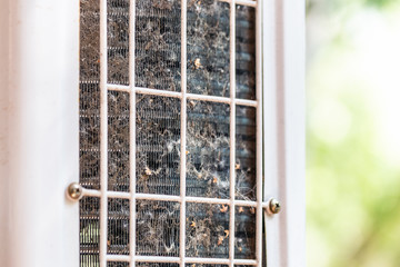 Close-up outdoor air condition unit with clogged obstructed compressor radiator grill. Details of air conditioner needed to clean and maintenance. House climate system check up and service