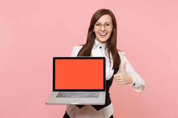 Young laughing business woman in glasses hold laptop computer with blank empty screen showing thumb up isolated on pink background. Lady boss. Achievement career wealth. Copy space for advertisement.