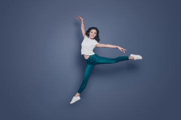 Fototapeta na wymiar Graceful magnificent attractive pretty stylish trendy nice lovely cheerful curly-haired brunette girl in casual white t-shirt and jeans, flying in air, dancing like ballet, isolated on grey background