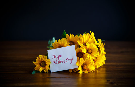 Fototapeta bouquet of yellow big daisies on a black