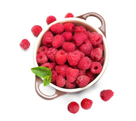 Pot with ripe raspberries on white background