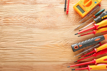 Different electrician's tools on wooden background