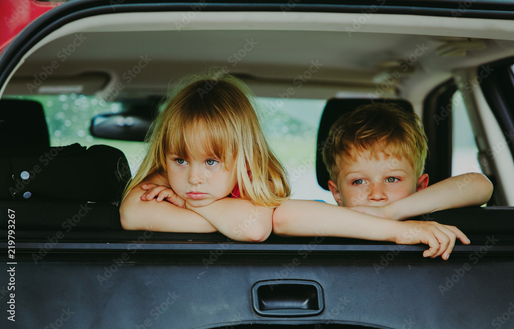 Wall mural little girl and boy waiting in car bored sad tired