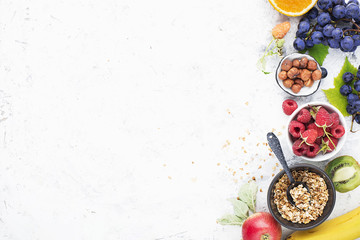 Ingredients for healthy breakfast meals: raspberries, blueberries, nuts, orange, bananas, grapes blue, green, apples, kiwi. Top View. - obrazy, fototapety, plakaty