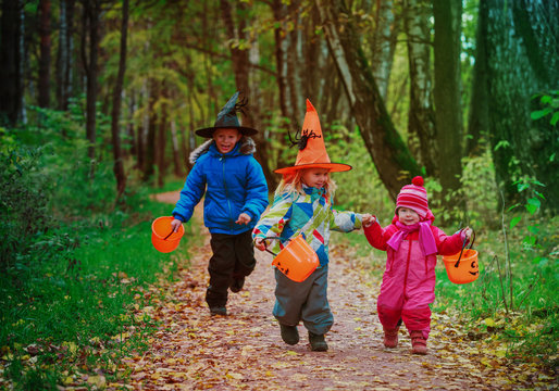 kids in halloween costume trick or treating in autumn nature