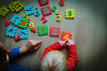 teacher and child play with number puzzle