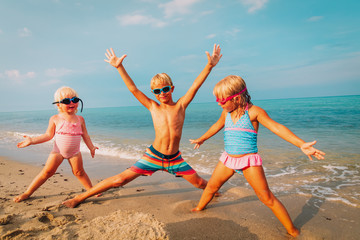 happy kids- little girls and boy-play enjoy beach