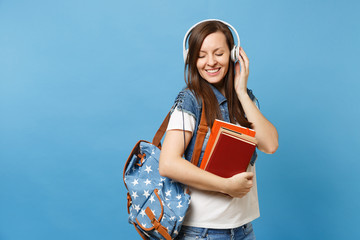 Portrait of young cute relaxed woman student in denim clothes with backpack headphones listen...