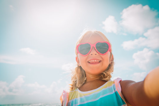 selfie of cute happy little girl at beach