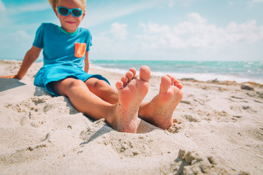 little boy relax at summer beach, focus on feet