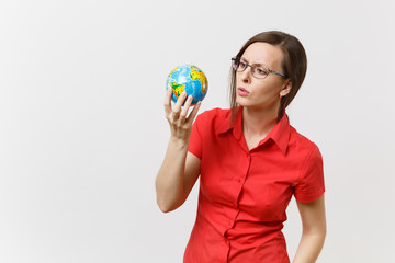 Shocked sad business or teacher woman in red shirt holding in palms Earth globe isolated on white background. Problem of environmental pollution. Stop nature garbage, environment protection concept.