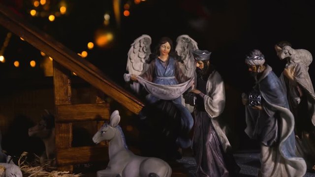 Jesus Christ Nativity scene with atmospheric lights. Jesus Christ birth in a stable with Mary and Joseph figures. Christmas scene. Dolly shot 4k