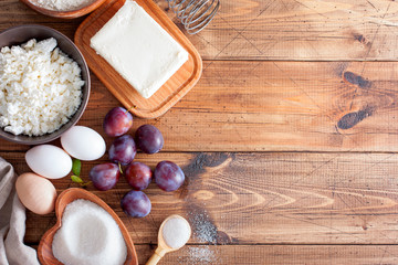 Ingredients for preparation of curd pastries with plums, top view