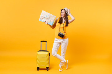 Traveler tourist woman in summer casual clothes, hat with suitcase, city map isolated on yellow orange background. Passenger traveling abroad to travel on weekends getaway. Air flight journey concept.