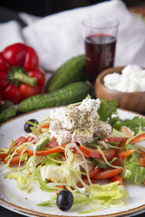 Tasty Greek salad with fresh vegetables, feta cheese and black olives on a plate