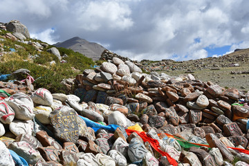 Tibet. Buddhist prayer stones with mantras and ritual drawings on the trail from the town of...