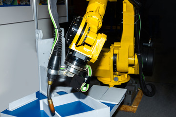 Yellow welding plasma kuka robot hand using in heavy industry for manufacturing, engineer processing or assemblies metal parts of machines