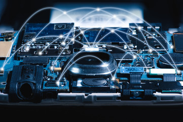 The abstract image of the motherboard illumination inside a smartphone overlay with networking line. The concept of telecommunication, digital, futuristic, electronics and technology.