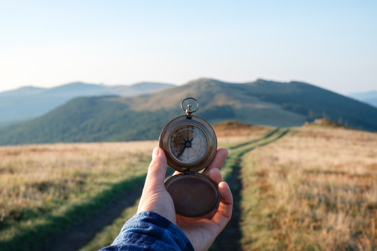 Man With Compass In Hand On Mountains Road. Travel Concept. Landscape Photography