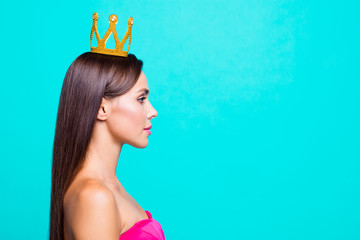 Half faced turned close up studio photo portrait of pretty attractive confident charming cute lovely serious lady wearing crown on head isolated on bright vivid blue background © deagreez