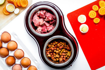 food for pets with meat and eggs on kitchen background top view