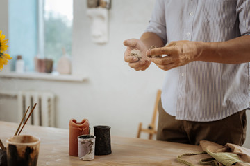 Little pots. Creative professional handicraftsman making little pots for house plants while working hard