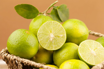 Green lime in basket with brown background, Lemon