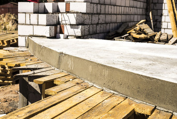 Smooth concrete surface. The Foundation without shoring. Concrete floor and unfinished wall, with protruding reinforcement.