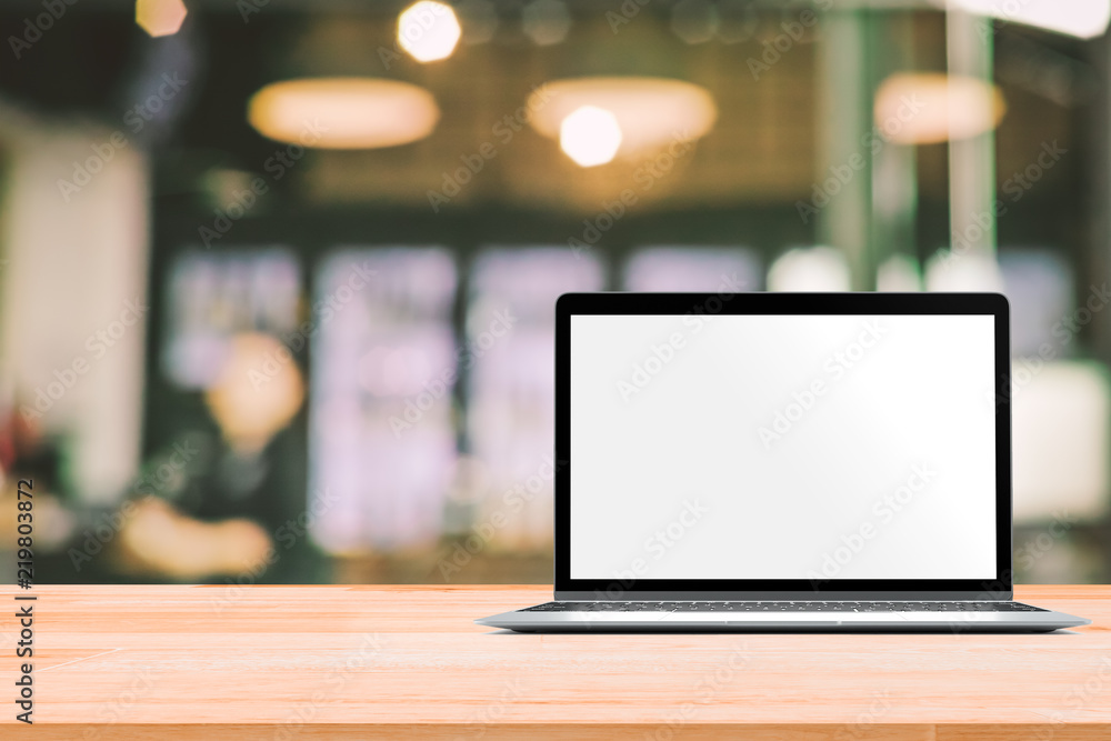 Poster laptop with blank screen placed on white wooden table in blurred people in coffee shop or restaurant