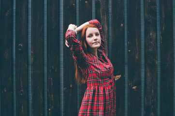 Beautiful autumn red hair model in front of wood wall