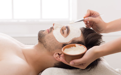 Man getting facial nourishing mask at spa salon