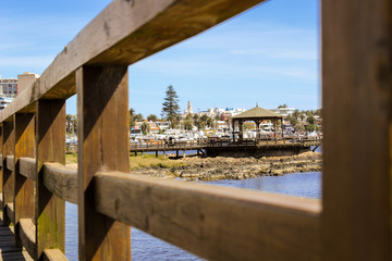 Fototapeta premium Mirando a través de una barandilla de madera en Punta del Este