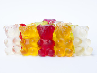Gummy bears candy in a row on white isolated background.