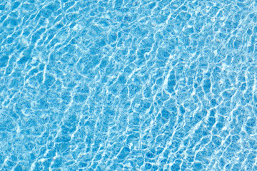 Fototapeta na wymiar The movement of water in the blue pool with sun glare. Background image.
