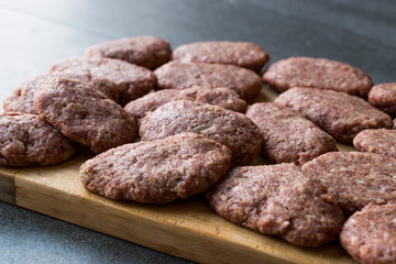 Turkish Raw Meatballs Kofte or Kofta made with Minced Meat on Wooden Surface.