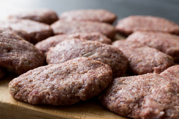 Turkish Raw Meatballs Kofte or Kofta made with Minced Meat on Wooden Surface.