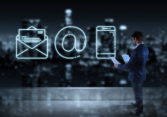 Businessman watching contact icon on the top of a building