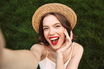 Above view of Cheerful woman in dress and straw hat