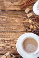 Cup of coffee, brown sugar and cinnamon with anise on a wooden background. Copy space
