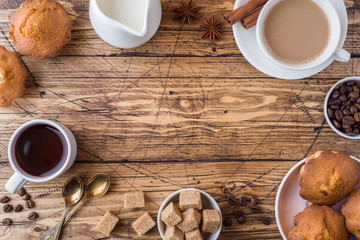 Breakfast and coffee for two persons, pastries, brown sugar and cinnamon with anise on a wooden background.
