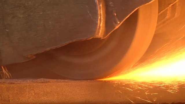 Fire sparks from under the abrasive wheel. The process of grinding cast iron products. Grinding on a surface grinding machine.