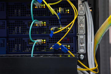 Close up fiber optic in server room , network cables installed in the rack Abstract image for use as a background