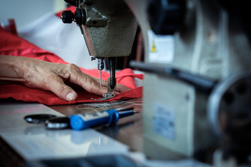 Woman's hands sewing fabric  repairs on old sewing
