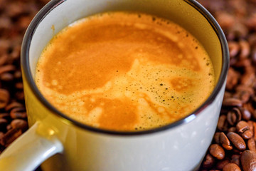a cup of coffee on a background of coffee beans