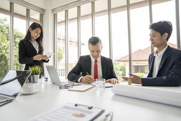 Young business man signing contract in meeting room.