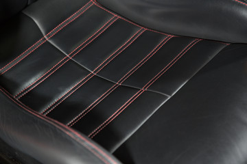 Red stitching on black leather car seat