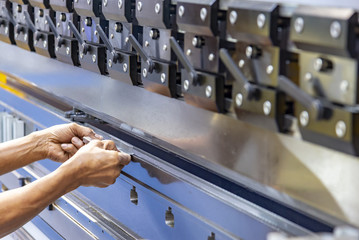 The technician operator use hydraulic bending machine. The sheet metal manufacturing process.