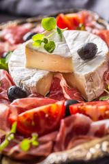 Cheese camambert from prosciutto tomatoes olives and oregano.