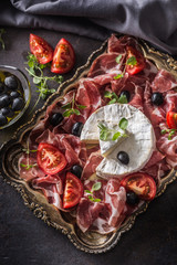 Obraz na płótnie Canvas Cheese camambert from prosciutto tomatoes olives and oregano.